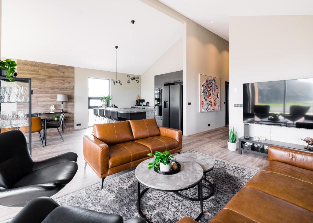 a living room with leather furniture and a table at Luxury Ocean Villas in Vestmannaeyjar