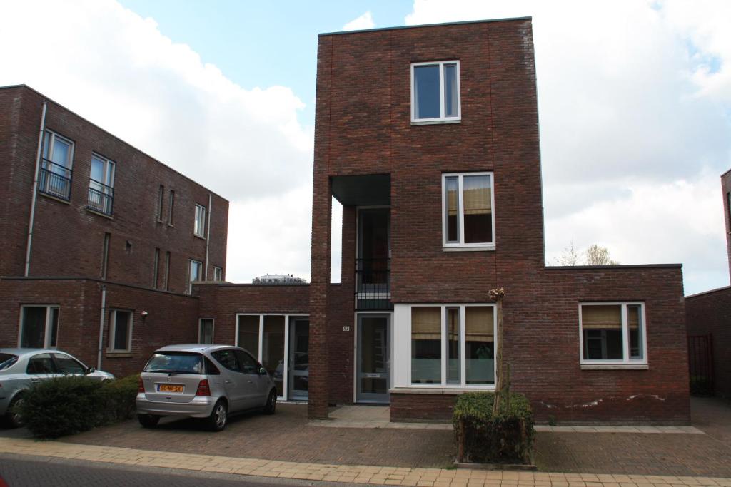 een bakstenen gebouw met een auto ervoor geparkeerd bij Floriande Bed & Breakfast in Hoofddorp