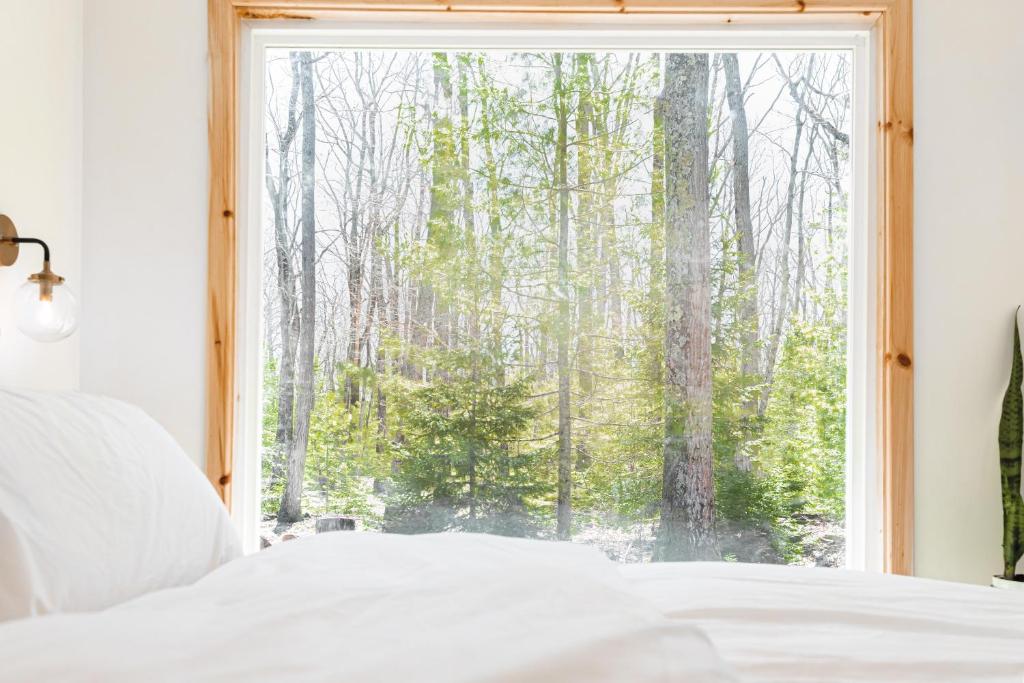 a bedroom with a window looking out at the forest at The Rex in Greentown