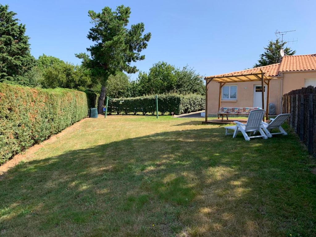 zwei Stühle im Gras im Garten in der Unterkunft les mouettes in LʼÎle-dʼOlonne