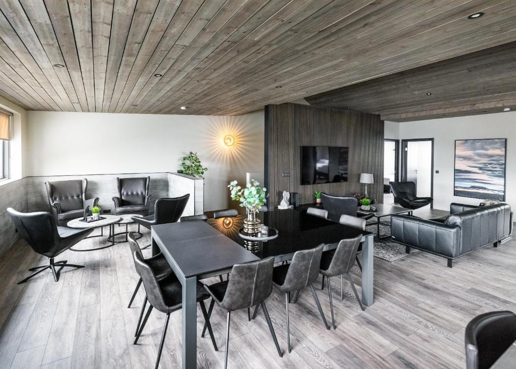 ein Wohnzimmer mit einem Tisch, Stühlen und einem Sofa in der Unterkunft Pier Apartments in Vestmannaeyjar