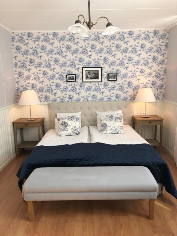 Nautic Hotell في مارستراند: غرفة نوم بسرير وورق جدران ازرق وابيض