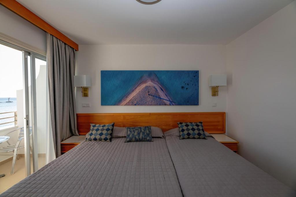 a bedroom with a large bed with two pillows at Tylos Beach Hotel in Kato Pyrgos