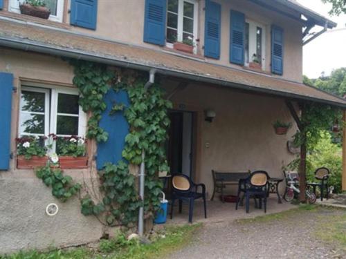 una casa con puerta azul, mesa y sillas en Auberge d'Hôtes l'Instant, en Le Hohwald