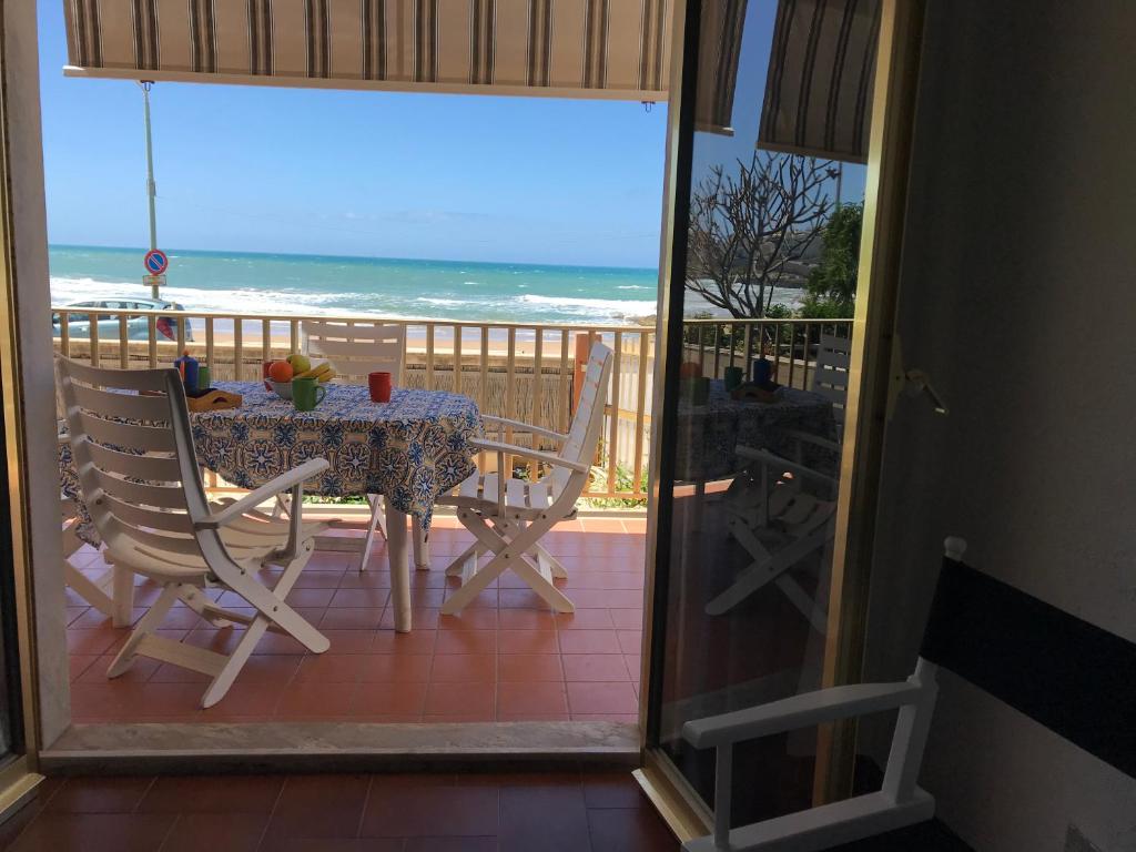 un tavolo e sedie su un balcone con vista sull'oceano di Casa sul lungomare a Donnalucata