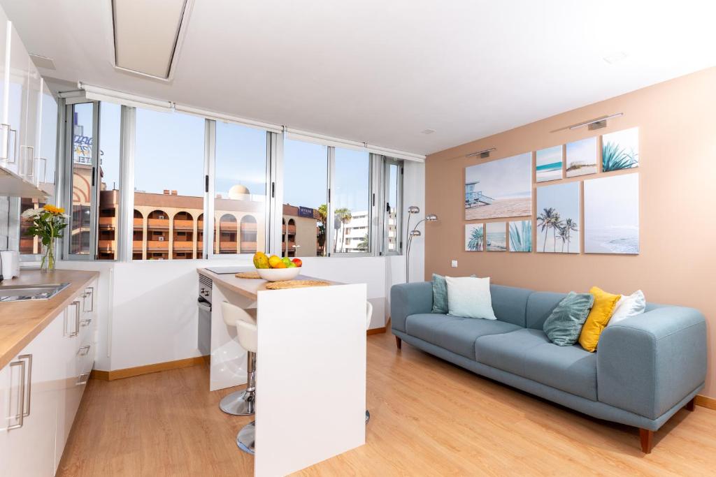 een keuken en woonkamer met een bank en een tafel bij Yumbo Teror Two Bedroom Apartment in Playa del Inglés
