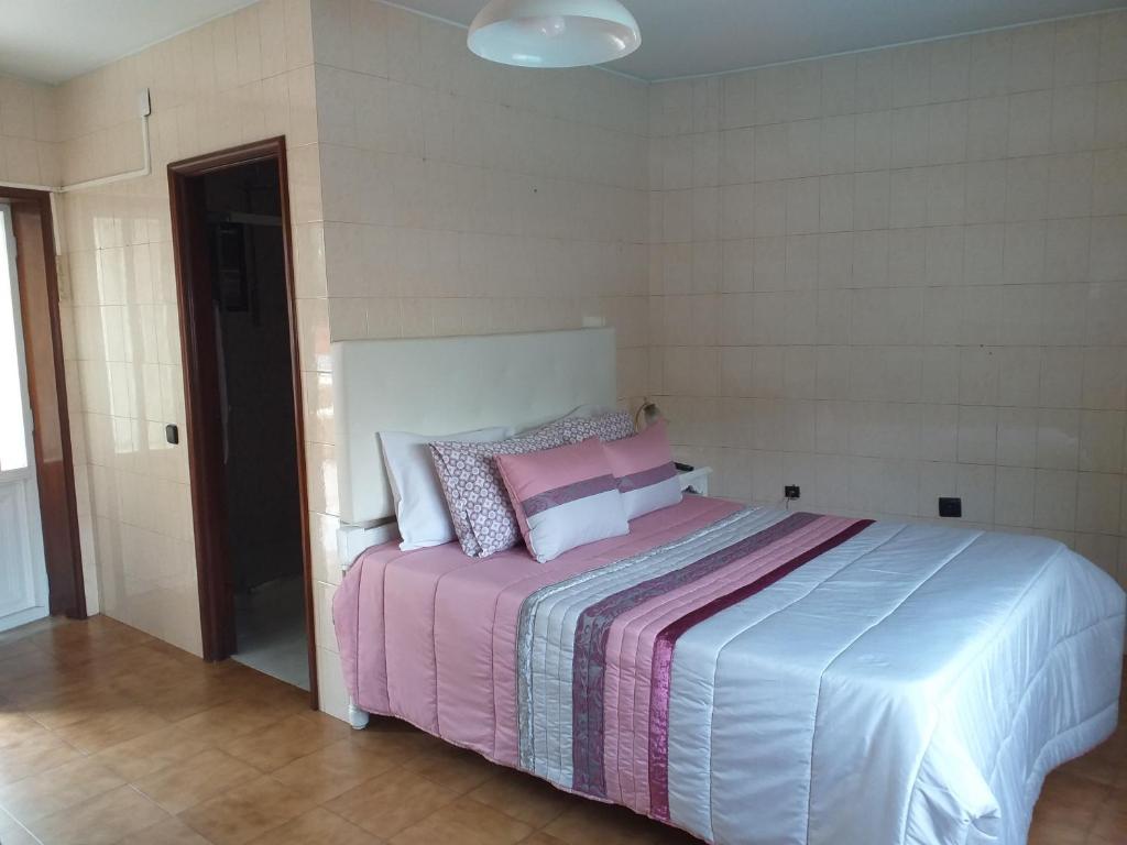 a bedroom with a bed with a pink and blue blanket at Enjoy Guest House GMR in Guimarães