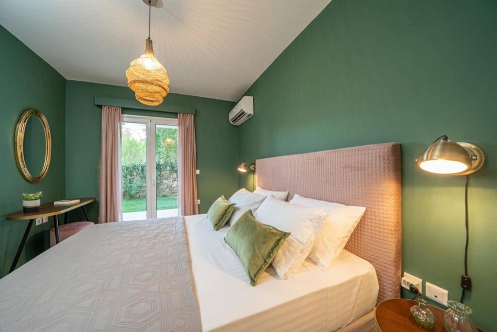 sypialnia z zielonymi ścianami i łóżkiem z poduszkami w obiekcie Central & Elegant Suite with private garden w mieście Argostoli