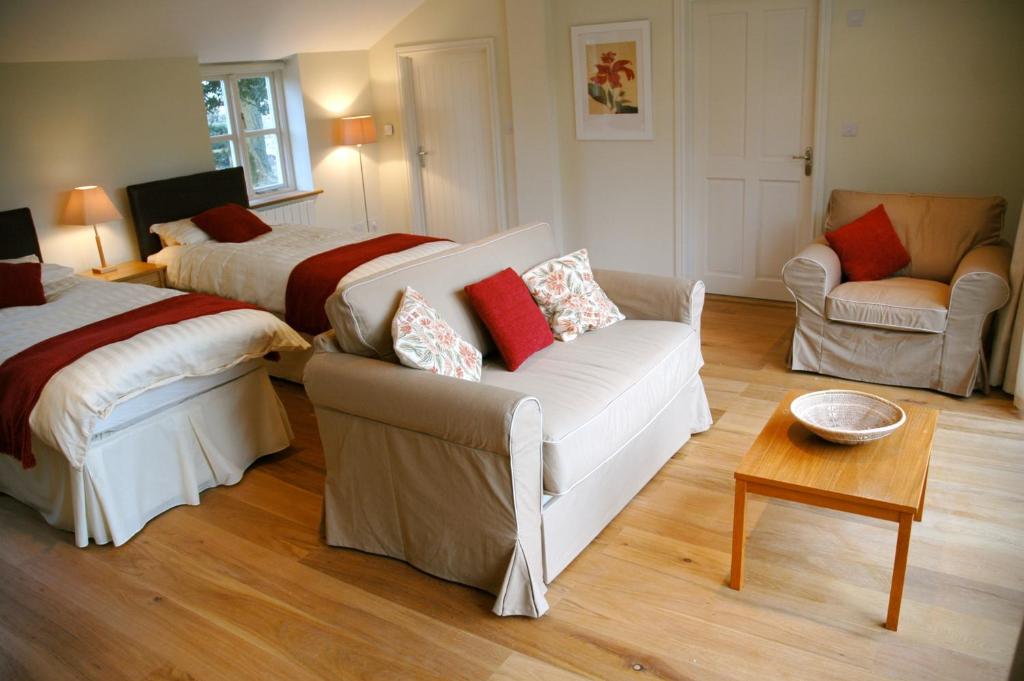 een woonkamer met 2 bedden en een bank bij Field Cottage Bed and Continental Breakfast in East Harling