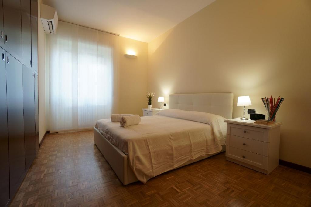 sypialnia z łóżkiem, komodą i oknem w obiekcie Residenza Feltre w Mediolanie