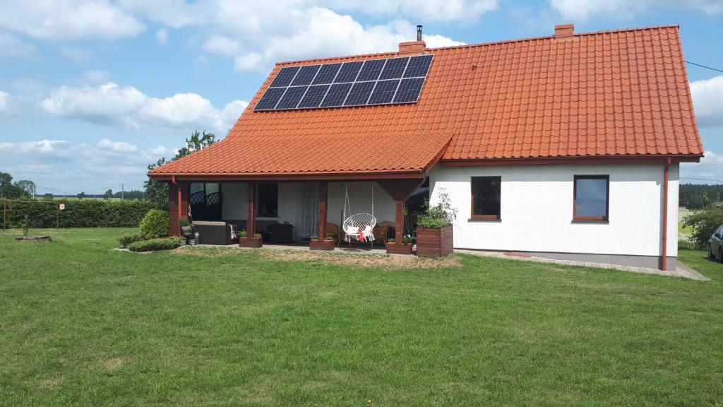 ein weißes Haus mit Sonnenkollektoren auf dem Dach in der Unterkunft Ranczo in Działek