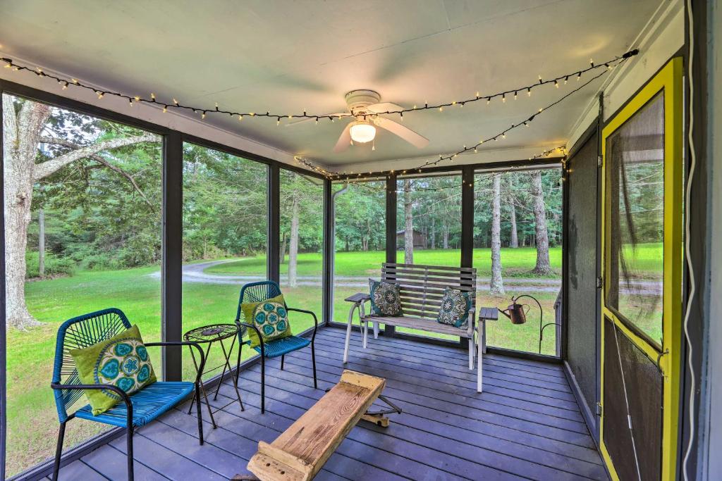 a screened porch with chairs and a bench at Rustic Hideaway with Fire Pit Less Than 1 Mi to River! in Hillsboro
