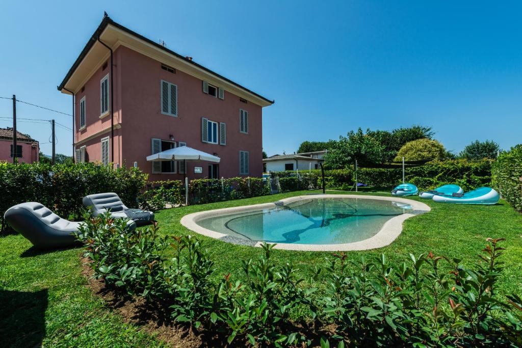 einen Hinterhof mit einem Pool und einem Haus in der Unterkunft il buen retiro in Lucca