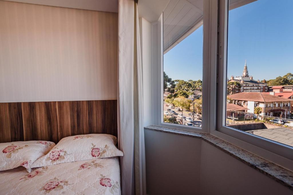 une chambre avec un lit et une fenêtre avec vue dans l'établissement Serra Nevada Apartamento - Vista Catedral de Pedra, à Canela