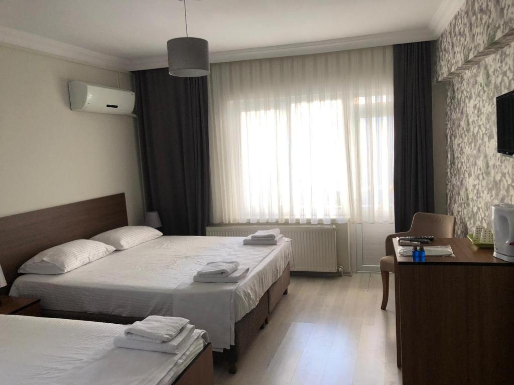 a hotel room with two beds and a window at Özdemir Otel in Balıkesir