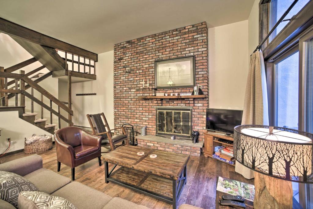 a living room with a brick fireplace and a couch at Immaculate Winter Getaway Near Skiing and Hiking! in Windham