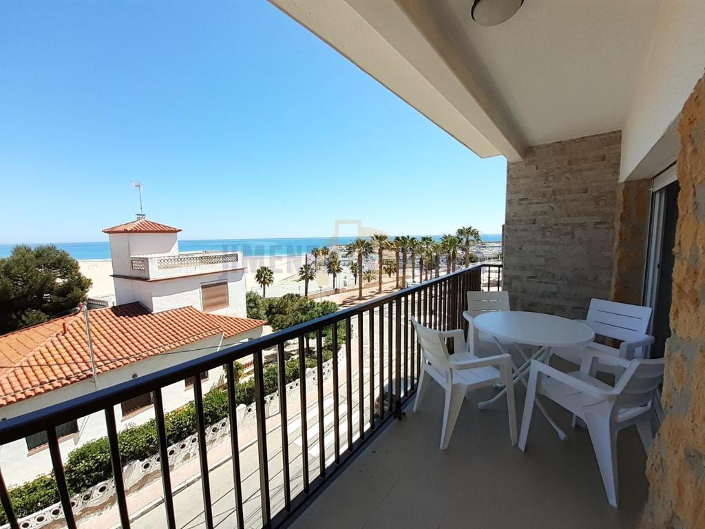 balkon ze stołem i krzesłami oraz plażą w obiekcie Apartamentos Dins Mar Apto. 7 w mieście Torredembarra
