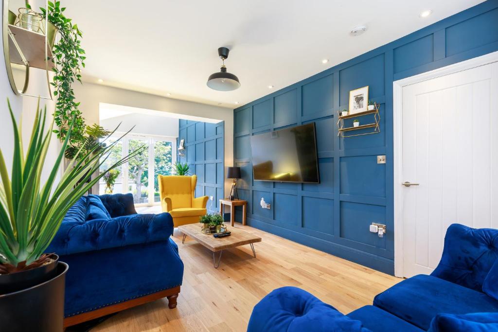 a living room with blue walls and blue furniture at 3Bed house with games room, hot tub & free parking in Brighton & Hove