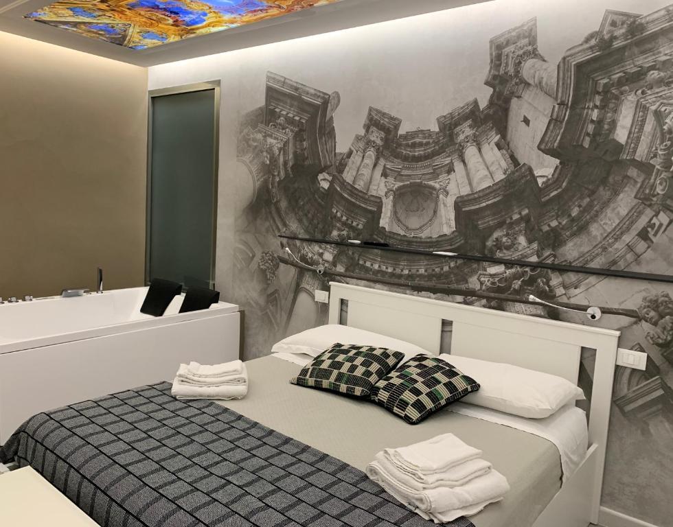 una camera da letto con un letto e un dipinto sul muro di Suite del Ponte Normanno Vespro a Palermo