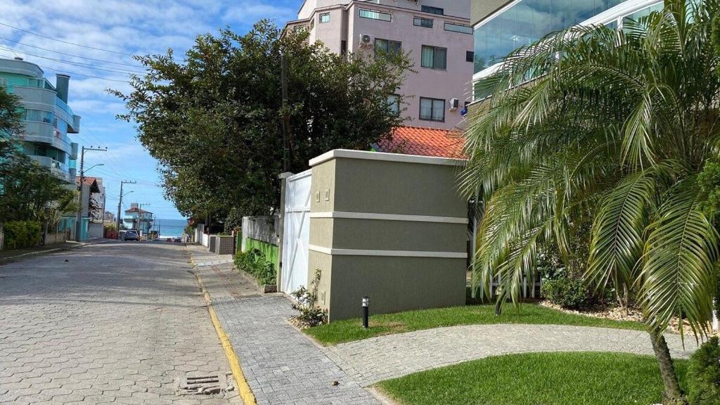 una calle vacía con un edificio y una palmera en Garden Ville · Confortável apartamento na Praia de Bombas com ótima localização, en Bombinhas