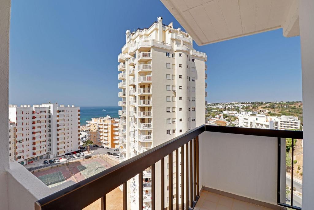 einen Balkon mit Blick auf ein weißes Gebäude in der Unterkunft Armacao de Pera Ocean View by Homing in Armação de Pêra