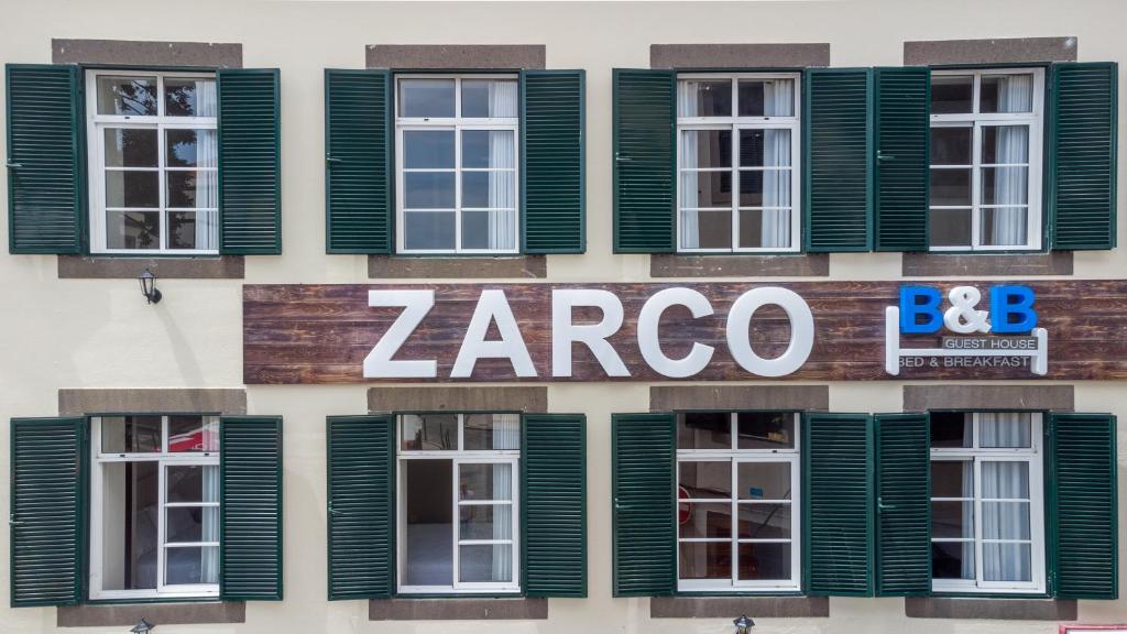 fachada de un edificio con ventanas de contraventanas verdes en Zarco B&B Bed & Breakfast, en Funchal