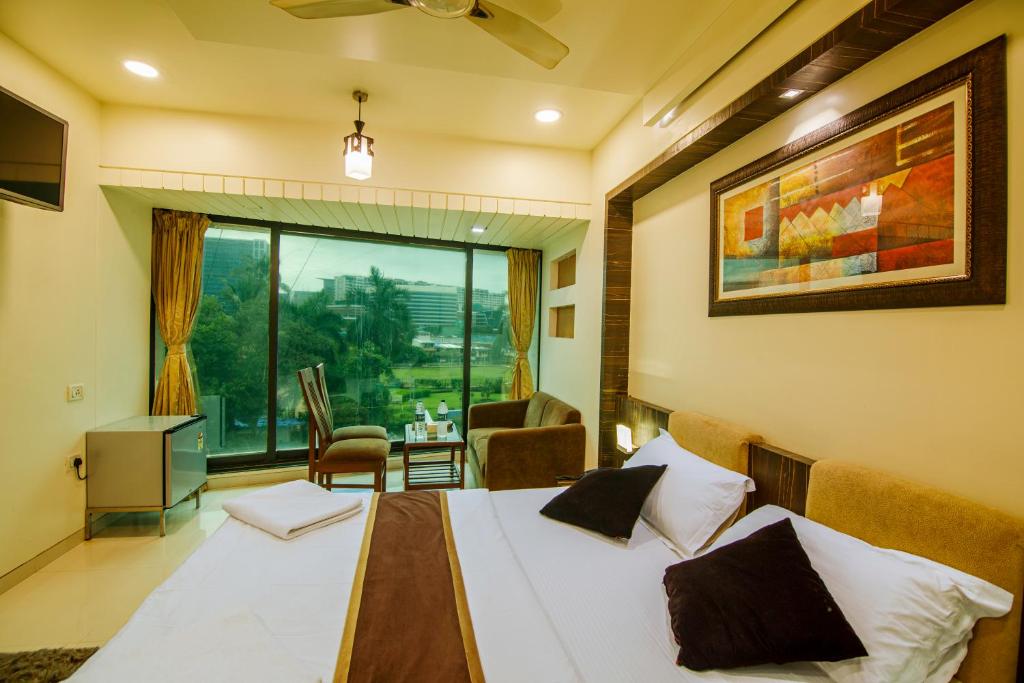 a bedroom with a bed and a window with a view at La Hotel Metro near BKC in Mumbai