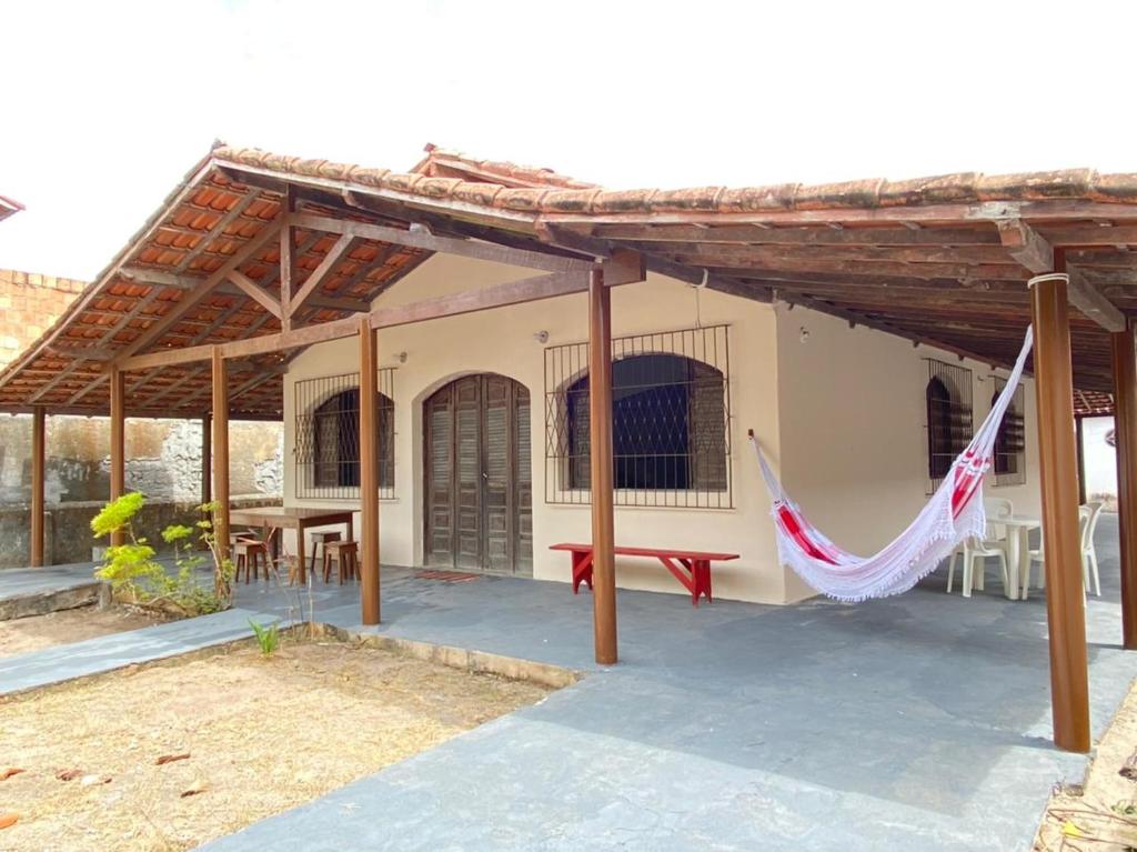a house with a hammock in front of it at Casa para temporada - Praia de Alcobaça - Bahia - em frente ao Condomínio Gaivotas in Alcobaça