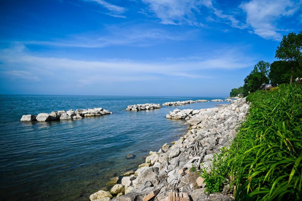 a body of water with rocks in the water at The Lakehouse Inn Geneva in Geneva-on-the-Lake