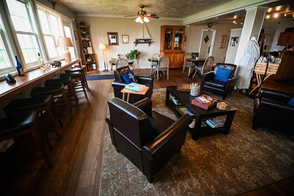 a living room with leather furniture and a bar at The Lakehouse Inn Geneva in Geneva-on-the-Lake