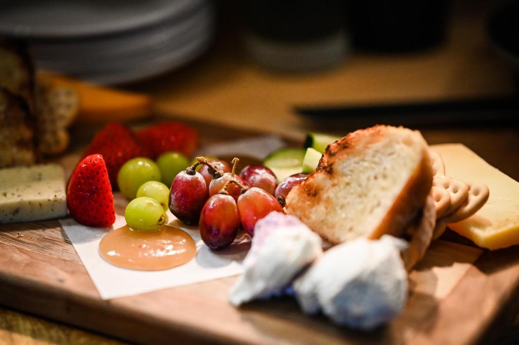 a plate of food with fruit on a cutting board at The Lakehouse Inn Geneva in Geneva-on-the-Lake