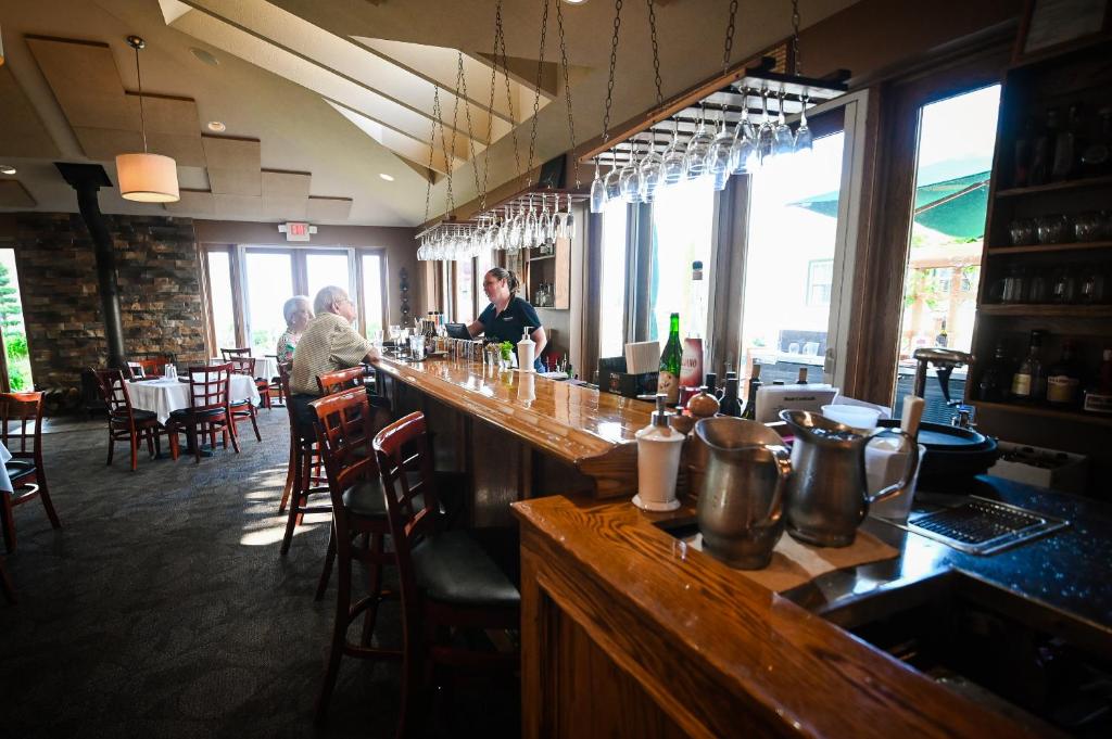 a bar in a restaurant with people sitting at tables at The Lakehouse Inn Geneva in Geneva-on-the-Lake