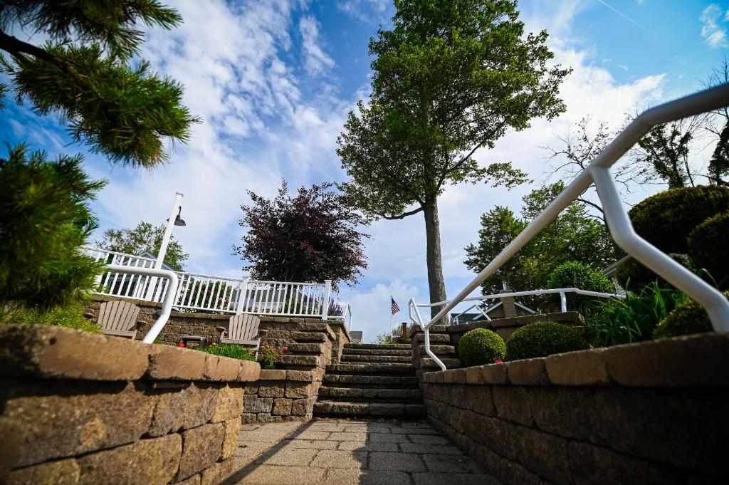a set of stairs with a white railing and a tree at The Lakehouse Inn Geneva in Geneva-on-the-Lake