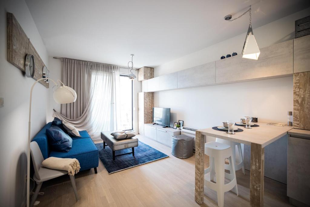 eine Küche und ein Wohnzimmer mit einem blauen Sofa und einem Tisch in der Unterkunft Island View Luxury Apartments in Zadar