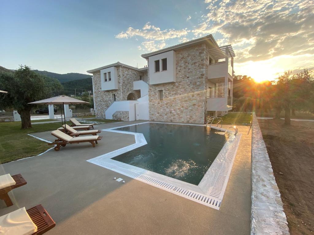 une villa avec une piscine en face d'une maison dans l'établissement Luminous Luxury Apartments, à Thasos