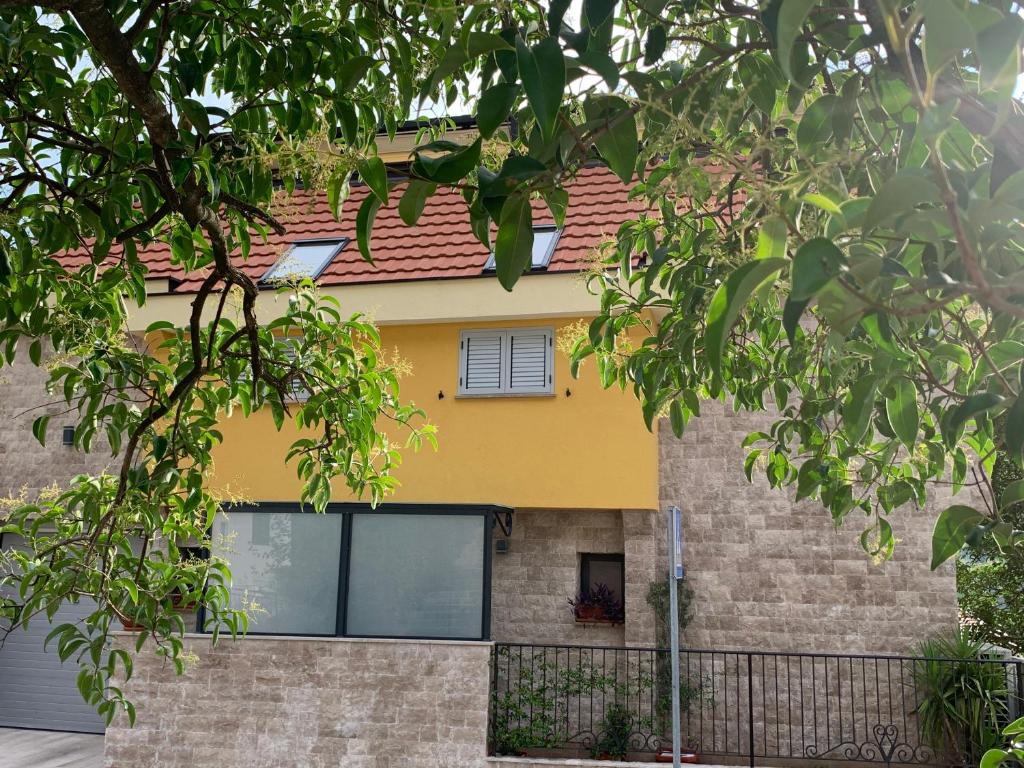 ein gelbes Haus mit rotem Dach in der Unterkunft Villa Lili in Kotor