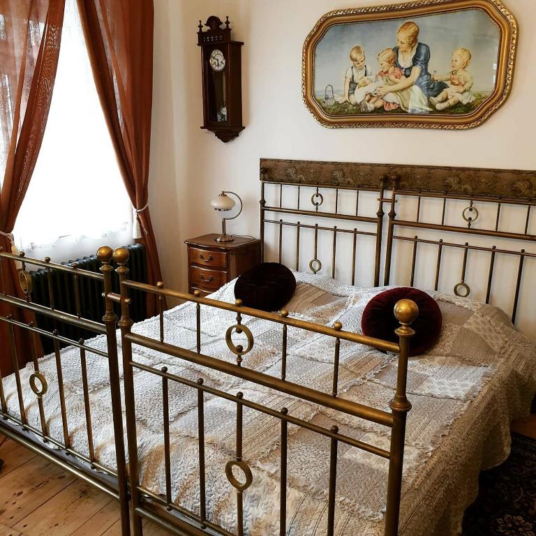 sypialnia z łóżkiem i obrazem na ścianie w obiekcie Zlatá léta - apartmánový dům Jáchymov w mieście Jáchymov