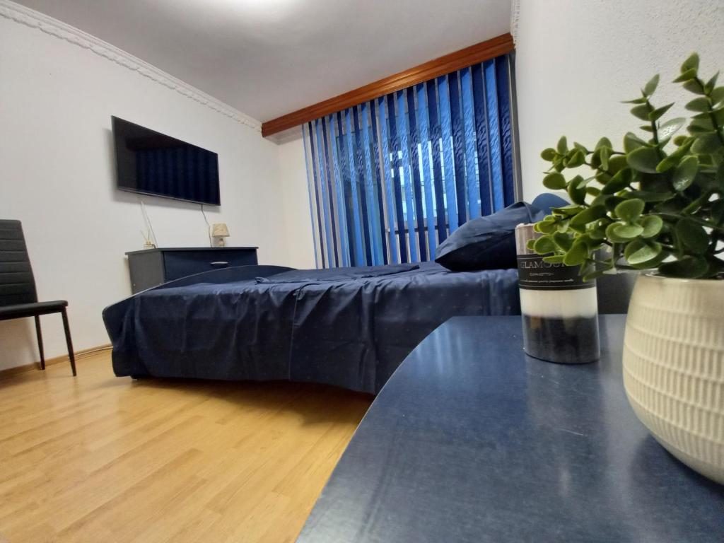 a bedroom with a bed and a table and a window at ALMA Apartament in Piatra Neamţ