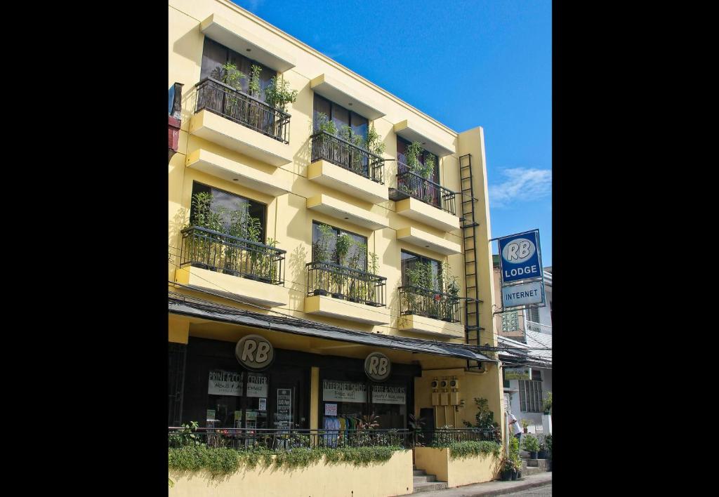 un edificio alto de color amarillo con balcones en una calle en RB Bed and Breakfast en Kalibo