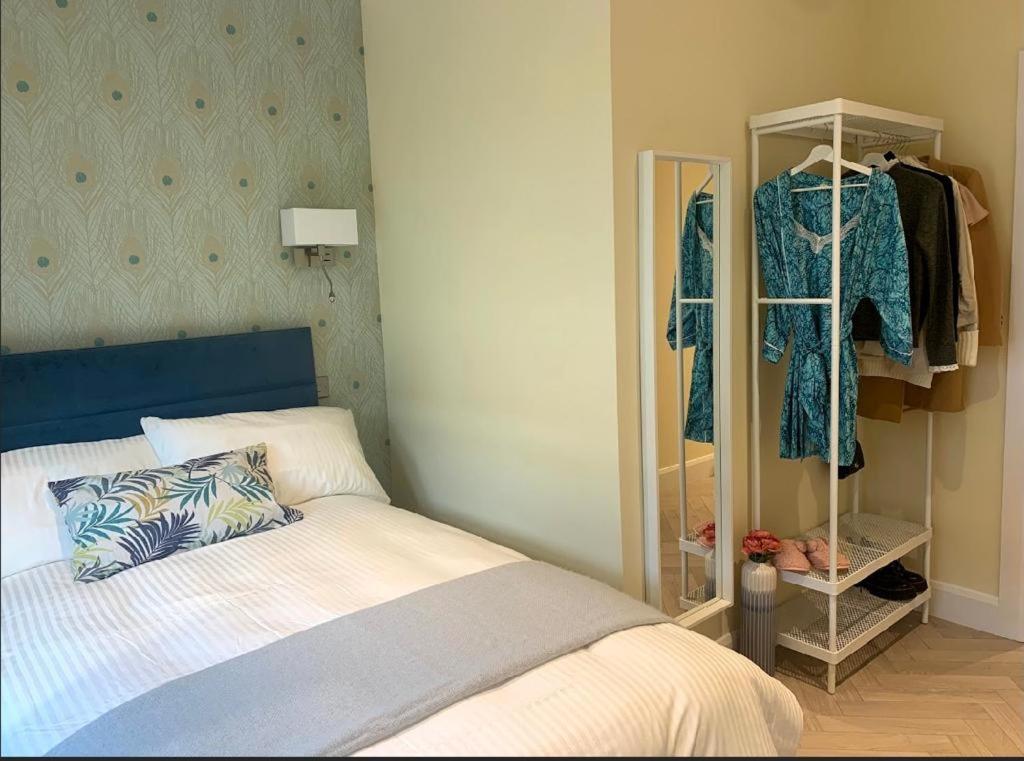 a bedroom with a bed and a closet with clothes at Apartment, Kilkenny City in Kilkenny