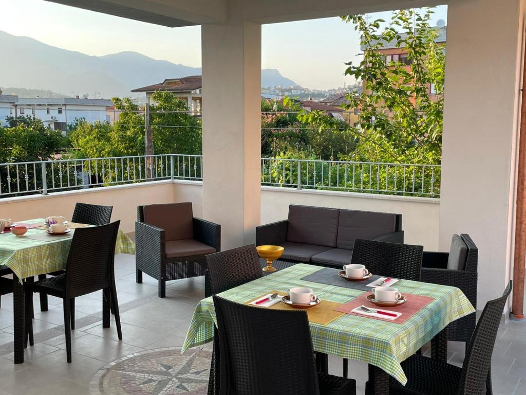 een patio met 2 tafels en stoelen en een balkon bij B&B Angelina in Minturno