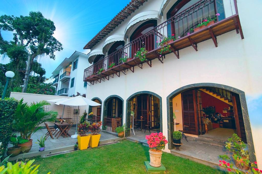 een huis met een patio en een balkon met bloemen bij Rede Reserva Santa Teresa in Rio de Janeiro