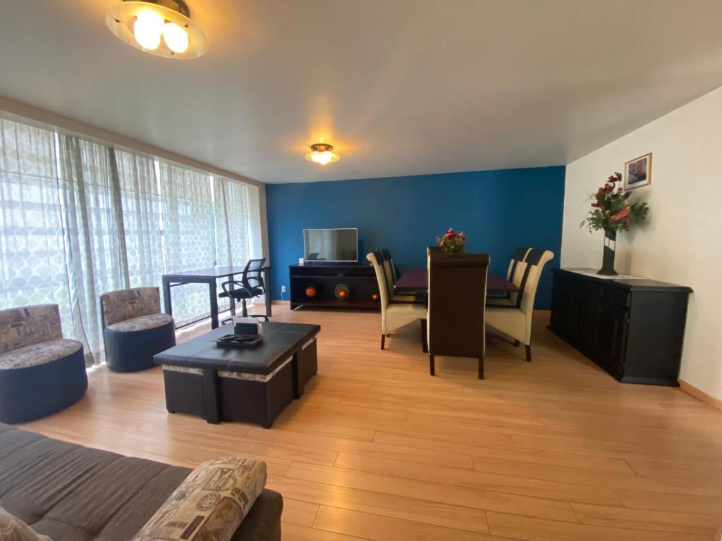 a living room with a couch and chairs and a television at Sinaloa 46 in Mexico City