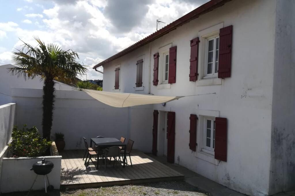 比達爾的住宿－La maison d'Amatxi, à 150m de la plage，白色的房子,配有桌子和棕榈树