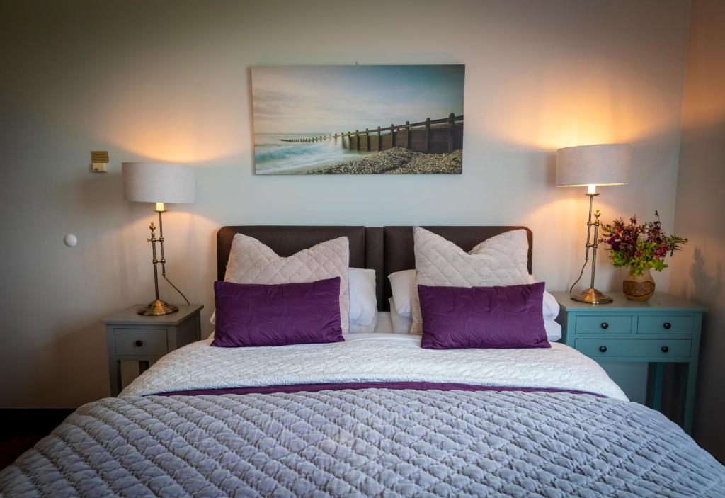 um quarto com uma cama com almofadas roxas e um cais em Bunratty Meadows Bed & Breakfast em Bunratty