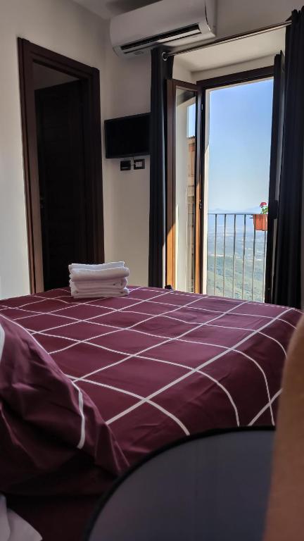 a bedroom with a purple bed with a view of the ocean at “Sa Scala” Bed&Terrace in Baunei