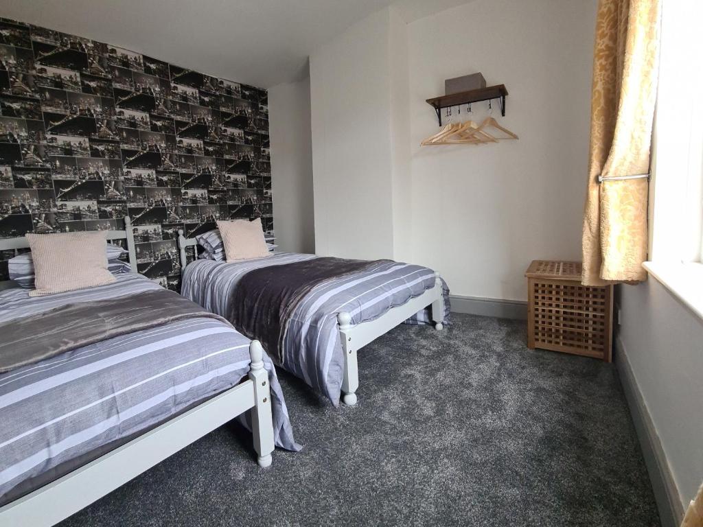 Pelton的住宿－1 Grange Street，一间卧室设有两张床和一张带照片的墙壁