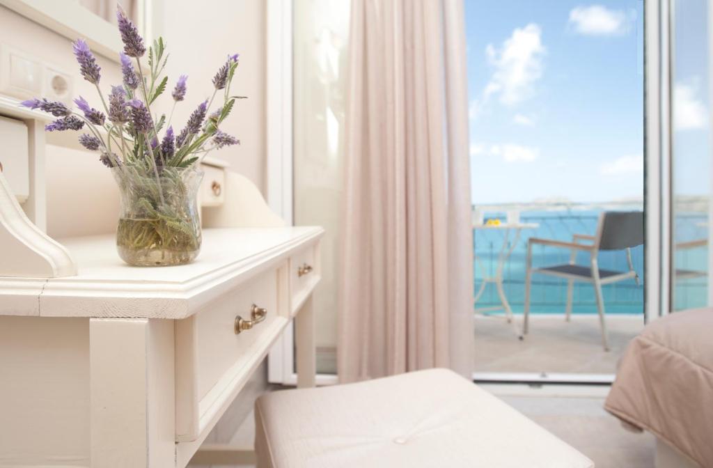 a vase of purple flowers on a table in a bedroom at Tina's House in Pylos