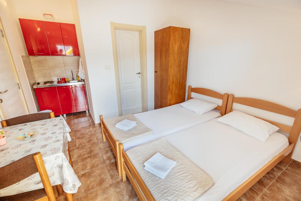 um pequeno quarto com duas camas e uma mesa em Anastasija5 em Herceg-Novi