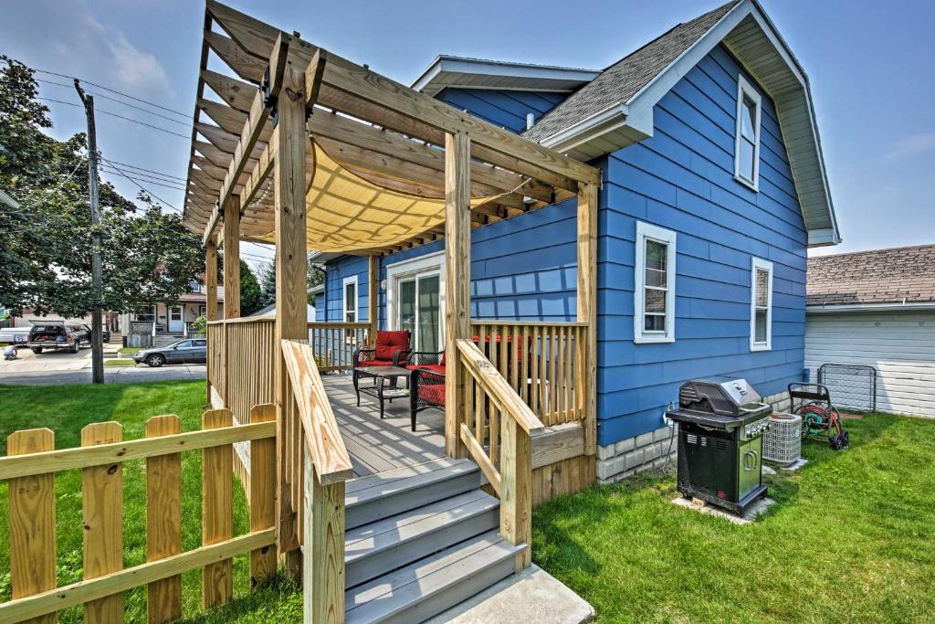 una casa blu con terrazza e griglia di Anias Retreat with Deck Walk to Lake Michigan! a Two Rivers